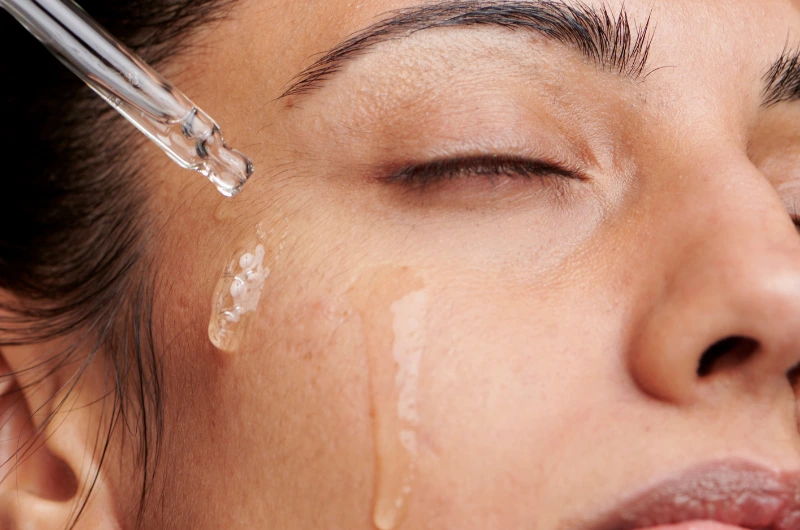 žena stavlja serum vitamin c na lice